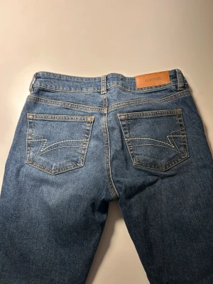 Blå bootcut jeans från Junkyard - Snygga blå bootcut jeans från Junkyard med klassiska fickor och coola sömdetaljer på baksidan. Perfekta för dig som gillar en avslappnad och trendig look.