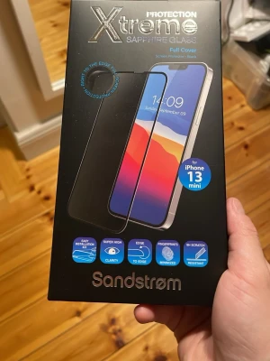 Sandstrøm Xtreme skärmskydd iPhone 13 mini - Skyddande Xtreme Sapphire Glass skärmskydd från Sandstrøm för iPhone 13 mini. Full Cover-modell i svart med safirinfusion, härdat glas och silikonlim. Ger superhög klarhet, kant-till-kant-skydd och är reptåligt samt minimerar fingeravtryck.