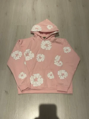 Rosa DENIM TEARS hoodie - Snabb leverans. Priset kan vi snacka om. Men Säljer en rosa hoodie med huva och stora vita molnliknande tryck över hela plagget. Hoodien har en klassisk känguruficka framtill och ribbade muddar vid ärmsluten. Materialet känns mjukt och bek yet.