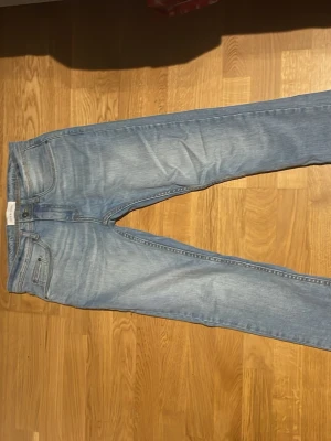 Ljusblå raka jeans från pier one - Säljer ett par ljusblå jeans från pier one med klassisk femficksmodell och raka ben. Jeansen har en snygg tvättad look och är tillverkade i bomull med lite stretch för extra komfort. Perfekta till en avslappnad stil.