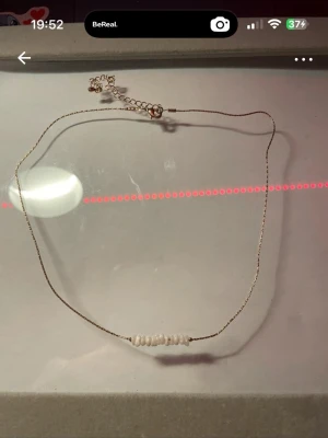 Tunt halsband med vita pärlor - Ett minimalistiskt halsband med en tunn kedja i silverfärg och små vita pärlor centrerade framtill. Perfekt för dig som gillar enkel och stilren design. Justerbar längd med förlängningskedja. Min 36cm max 47cm🖤aldrig använd