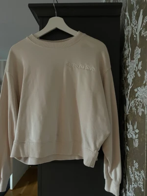 En beige tröja från HM  - En tröja från HM. På vänster bröst, står det nyc studios. Köpt i New York. Storlek S. Tröjan är inte så tjock. 