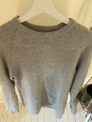 Ljusgrå stickad tröja, weekday - En enkel och stilren ljusgrå stickad Tröjan har ribbade muddar vid ärmslut och nederkant. Perfekt basplagg för lager på lager och funkar till det mesta. Inga defekter passar både s och m 