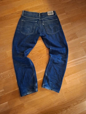 Levis jeans  - Mörkblå levis straight fit jeans I fint skick ändast en liten fläck på ena fickan storlek 30/30