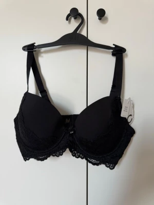 Oanvänd BH med spetsdetalj, Cubus - Säljer denna helt oanvända BH med snygga spetsdetaljer från Cubus🖤Prislappen är kvar! Köpte denna Bh men använde aldrig, därför säljer jag den nu💕storlek: C/70 orginalpris:249