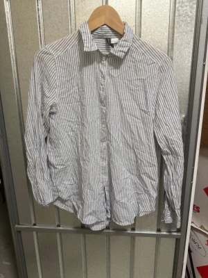 Randig skjorta - Fin blå/vitrandig skjorta. Lite tunnare tyg men inte genomskinlig. Använd några enstaka gånger.