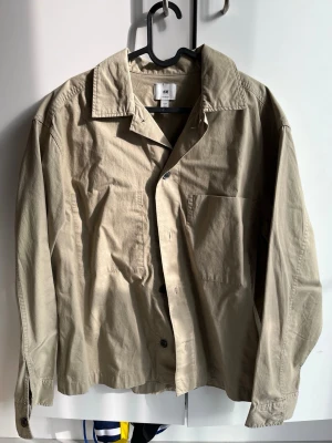 Beige overshirt från H&M  - Stilren beige overshirt från H&M i loose fit-modell. .