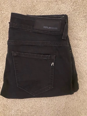 Svarta fit jeans från Replay - Säljer ett redigt par svarta slim fit jeans från Replay. Klassisk French five-pocket design, diskret Replay-logga på bakfick pipeline och svart patch i soppa. Sny boomer fit och stretchigt material som sitter skönt hela dagen.