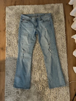 Ljusblåa Lågmidjade jeans - Jättesnygg jeans ifrån US Polo Assn. Står ingen storlek men skulle säga storlek M, jeansen har fina hål vid benen som man kan se på bilderna!! Skulle säga att de är bootcut / raka