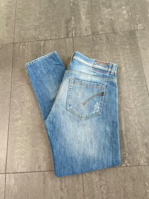 Dondup - Dondup George i storleken w35. Snygga slitningar och tvätt. Jeansen är i fint skick. Jeansen är uppsydda till 97cm ytterben. 