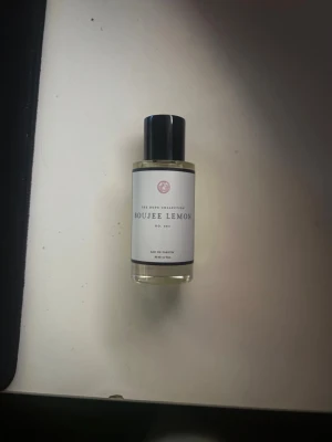 Boujee Lemon Eau de Parfum 50ml - Boujee Lemon från The Sote Collection är en fräsch parfym med citrusdoft. Flaskan är genomskinlig med svart lock och vit etikett. Innehållet är ljusgult och flaskan rymmer 50 ml. Perfekt för dig som gillar fräscha och energiska dofter.