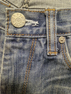 Blå jeans från Acne, Max Stencil 32/34 - Snygga blå jeans från Acne, Max Stencil, i storlek W32/L34 med klassisk femficksdesign och raka ben. Jeansen har ljus tvätt med subtila slitningar, silverfärgade nitar och knapp med Acne-logga. Passar dig som gillar stilrena och tidlösa jeans med normal passform.