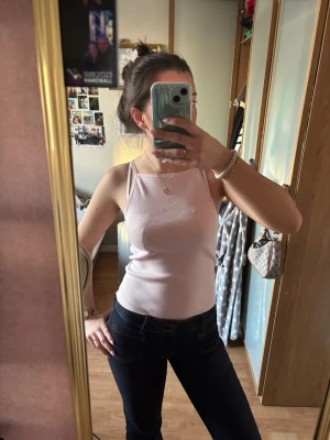 Ljusrosa linnetopp med knyt - Säljer en ljusrosa linnetopp med smala axelband och snygg knytning i ryggen. Toppen har en slim passning och är perfekt för sommarens varma dagar. Materialet känns mjukt och lätt.