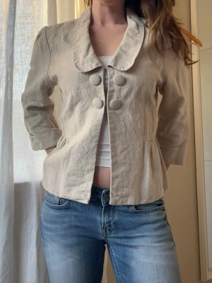 Sommar jacka kavaj i linne - Jättefin kavaj i linne med knappar. Perfekt som jacka till sommaren! Står ingen storlek men skulle uppskatta 36-38. Jag bär vanligtvis storlek 36.