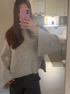 Stickad tröja - Ljusgrå stickad tröja från Ginatricot i storlek M. Den har en mindre slit på vardera sida och i ärmarna (se bild)