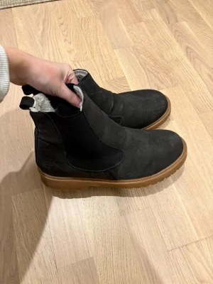 Svarta boots med foder - Snygga svarta boots, Bootsens insida är fodrad med mjukt, ljust material för extra värme. Perfekta för kyligare dagar.