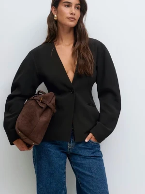 Svart kavaj med djup v-ringning - Stilren svart kavaj med djup v-ringning och en knapp framtill. Kavajen har figurnära passform och långa ärmar. Perfekt att matcha med jeans för en cool look. Köpt för 699kr använd 1 gång. Strl: S 