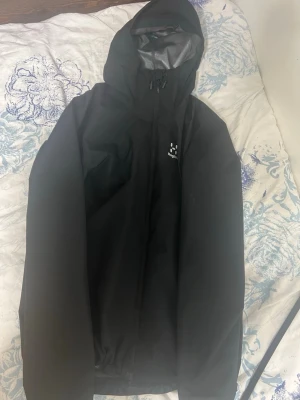 Svart regnjacka  Haglöfs   - Väldigt bra skick använd 1 gång size m 