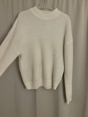 Vit stickad tröja från new yorker stl S  - En stilren vit stickad tröja. Tröjan har långa ärmar och ribbade muddar vid ärmslut och nederkant. Köpt på new yorker, är lite nopprig vid magen. 
