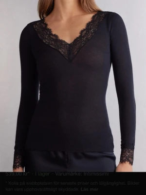 Svart spetsdetaljerad topp Intimissimi - Svart långärmad topp från Intimissimi med djup v-ringning och eleganta spetsdetaljer vid halsringning och ärmslut. Tunn och mjuk känsla, perfekt för att lyfta vilken outfit som helst. Figurnära passform och stilren design. Pris kan diskuteras litegrann. 
