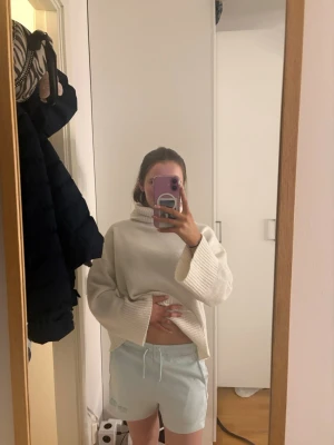 Ljusblå shorts med snörning - Säljer ett par ljusblå shorts med snörning i midjan. De har en relaxed passform och är tillverkade i mjukt bomullsmaterial. Perfekta för sommarens chill dagar och har en enkel design med diskret tryck på ena benet.