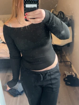 Svart topp - Trendig svart topp med lång ärm och tight passform. Perfekt att styla med både jeans och kjol för en cool look. Mjuk och stretchig känsla, enkel att matcha med olika outfits.