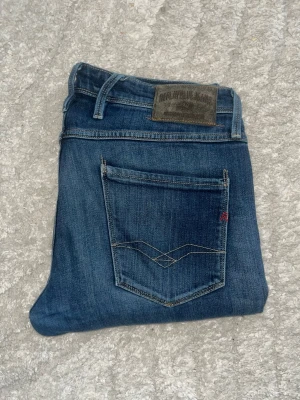 Replay Anbass jeans  - Klassiskt blåa Replay Anbass Jeans men fade. Midja 45cm, längd 107cm. JAG SKICKAR EJ FLER BILDER NÄR JAG BÄR JEANSEN! för bättre inblick i passformen rekommenderar jag att googla på modellnamnet. För storleksguide kolla måtten noggrant då jeansen alltid kan vara uppsydda heller krympta och jag ej tar emot returer :) 1,76