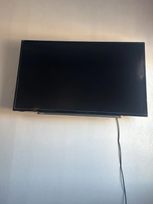 Toshiba 32" FHD QLED-TV med Chromecast - Säljer en svart 32-tums FHD QLED-TV från Toshiba med inbyggd röstassistent och Chromecast. Tunn och stilren design med smal ram, perfekt för streaming och gaming. TV:n har smarta funktioner och kan enkelt monteras på väggen eller stå på bänk.