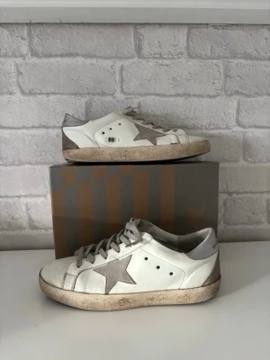 Golden goose skor - Säljer dessa välanvända golden goose skor till den som vill laga dem eller vill ha ett par skor att inte bry sig om. Diverse defekter som hål i ena hälen. Og box ingår 