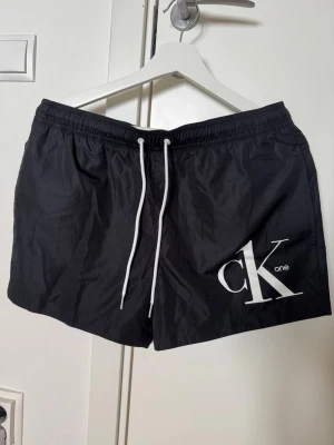 Badbyxor  - Riktigt snygga herr badbyxor från Calvin Klein. Normala i storlek. Som nya 