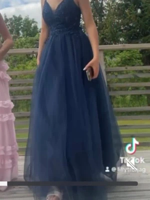 Marinblå balklänning  - Säljer min marinblåa balklänning nu då jag inte kommer få användning för den igen, klänningen sitter bra och är ej jobbig att ha på sig, modellen är ganska puffig i nederdelen och överdelen har stenar/glitter på sig. Klänningen är i väldigt bra skick då jag endast har använt den en gång och vi var endast inne då. Jag är 164cm lång men på bilderna har jag på mig klackskor var ca 5cm höga 💕