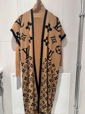 Beige klänning med kofta/poncho till - Snyggt set med beige lång kofta och långärmad klänning. Perfekt för en trendig och lyxig look.