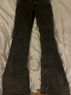 Svarta utsvängda jeans med kontrastsömmar - Snygga svarta jeans med utsvängda ben och markerade kontrastsömmar. Jeansen är mid waist 