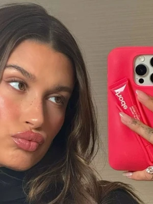 Rhode skal GUAVA SPRITZ - Säljer ett coolt rosa mobilskal med Sporty-logga, designat för iPhone. Skalet har en unik form med en ficka på baksidan som passar för småsaker som läppbalsam. Materialet är troligtvis silikon eller TPU och ger bra grepp och skydd. Kommer med skal och Läppglans HELT OANVÄND!! Perfekt för sommaren 🥹🥹❤️❤️❤️❤️❤️