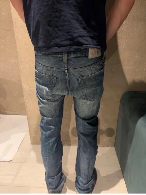 Tiger of sweden jeans - Snygga blåa slim fit jeans med lätt slitna detaljer och tvättad look. Klassisk femficksmodell med normal midja och raka ben. Perfekta för en avslappnad och trendig stil.