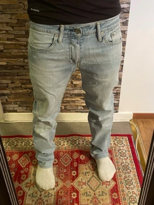 Ljusblå raka jeans herr - Säljer ett par ljusblå jeans med klassisk femficksdesign och raka ben. Jeansen har normal midja och stängs med knapp och dragkedja. Perfekta för en avslappnad och stilren look. Materialet är denim i bomull.