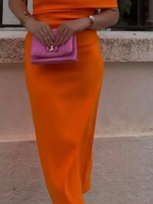 Orange axelbandsklänning helt ny. - Snygg orange klänning med  off shoulder på ena armen. Klänningen är i ett slätt, lätt material som ger en modern och trendig look. Perfekt för dig som vill sticka ut med färg. Helt ny, dock sitter inte prislapparna kvar. Storlek S.