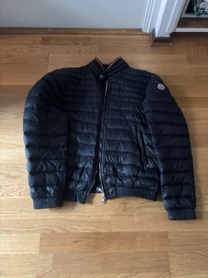 Moncler garin jacka(ÄKTA) - Snygg svart moncler garin jacka storlek S/M. Skick 8/10 det är några ställen som har svarta patches på där det har varit i sönder men detta är inget som märks vid användning. Priset är ej hugget i sten. Självklart äkta. Skriv vid frågor och funderingar 😁