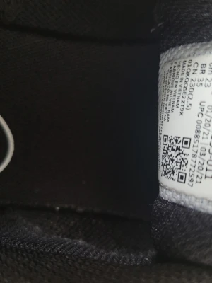 Svarta Nike sneakers med vit sula - Snygga svarta Nike sneakers med vit sula och stor vit swoosh på sidan. Ovandelen är i mesh-liknande material som andas och sulan har ett rutmönster för bra grepp. Perfekta för dig som gillar sportig och clean stil.