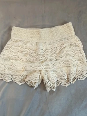  virkade shorts med volang - Superfina beiga/vita virkade shorts med bred resår i midjan  lappen är borta finns inte storlek men storleken är ca S och jag tror dem är från chelsie