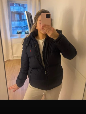 Svart pufferjacka från Polo Ralph Lauren - Säljer en svart pufferjacka från Polo Ralph Lauren, tecken på användning, storleken är XL i barnstorlek, skulle säga att jackan är S i dammodell 