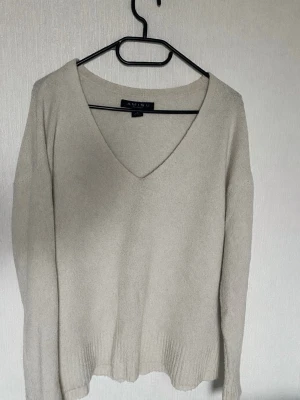 oversize stickad tröja  - Mysig beige stickad tröja från Amisu med djup V-ringning och långa ärmar. Perfekt att ha med jeans eller kjol.