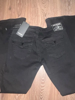 Svarta jeans från True Religion - HELT NYA! Svarta low waisted jeans från true religion. Aldrig använda eftersom jag köpte fel storlek för mig! Storlek 28, Original pris 1299! Priset kan abouslut diskuteras då jag helst bara vill bli av med dem