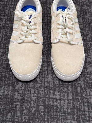 Adidas Originals Donnelly – Helt nya - Säljer ett par Adidas Originals Donnelly sneakers i beige mocka, storlek 44. Helt nya och oanvända. Stilren och klassisk modell som passar perfekt till både jeans och chinos.  Skick: Helt nya Storlek: 44 Material: Mocka  Hör gärna av dig vid frågor eller om du vill ha fler bilder