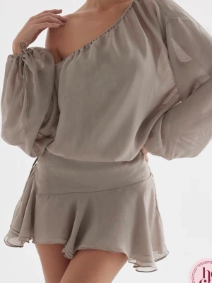 House of Cb klänning  - Grön klänning med oneshoulder-design och volangdetaljer. Klänningen har långa, puffiga ärmar med knyt vid handleden och en flowy kjol. Endast använd en gång 🫶