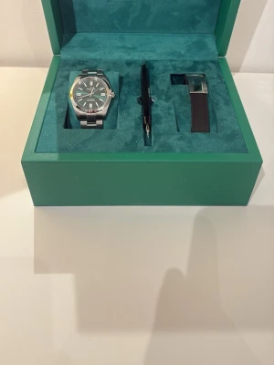 Marlow Miller klocka -  klockset med en stilren klocka i rostfritt stål, svart urtavla och silverfärgade detaljer. Setet innehåller även en extra länk och en penna, allt levererat i en grön lyxig box. Ny pris 2000 isch