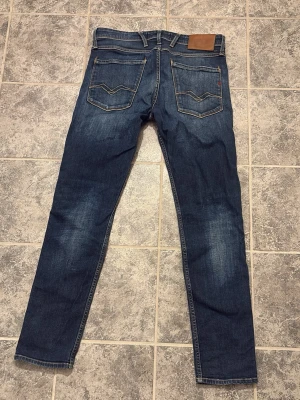 Replay anbass - Snygga mörkblå jeans från replay med klassiska kontrastsömmar och två bakfickor med V-formad detalj. Jeansen har en rak passform och är tillverkade i slitstarkt denim. Perfekta för dig som gillar en tidlös och avslappnad stil.