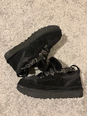 UGG Lowmel - Snygga svarta sneakers från UGG med grov sula, detaljer i mocka och mesh. Skorna har breda, mönstrade snören och en modern, chunky look. Perfekta för dig som vill ha både stil och komfort i vardagen. Riktigt bra nu till kyliga dagar. Allt på bilderna tillkommer samt extra snören, hör av er om ni har frågor✌️