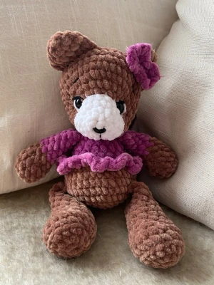 Brun virkad nallebjörn  -  Söt, handvirkad nallebjörn av mjukt chenillegarn. Mjukisdjuret är stoppad med polyesterfyllning och har säkerhetsögon och nos av plast. Nallen är ca 22 cm hög 🧶🐻 OBS! Pga plastögonen och nosen rekommenderas inte mjukisdjuret för barn under 3 år