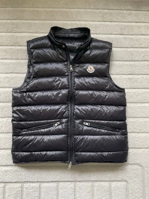 Moncler Gui Gilet Väst Svart Strl 2 (S) - Riktig fräsh Moncler Gui Gilet väst i svart, strl 2 (S). Fint skick, äkta dun med DIST-certifikat och QR-kod finns kvar. Fick i present, säljer vidare, hör av er vid frågor!